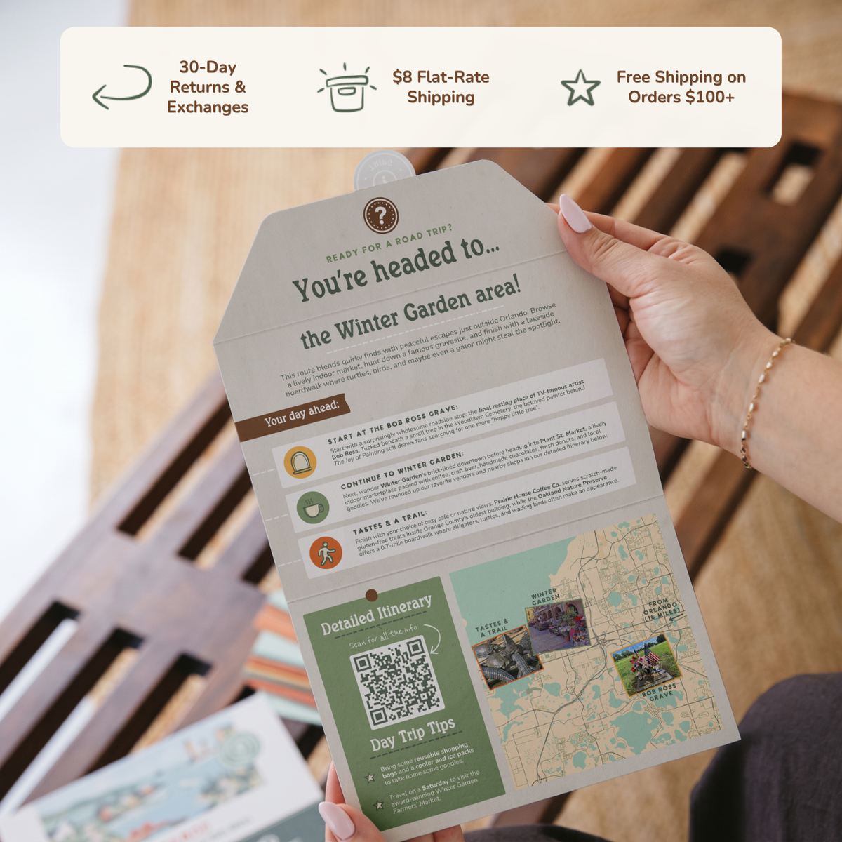 Hands holding an open itinerary card. Banner reads: 30-day returns and exchanges, $8 flat-rate shipping, free shipping on orders $100+.