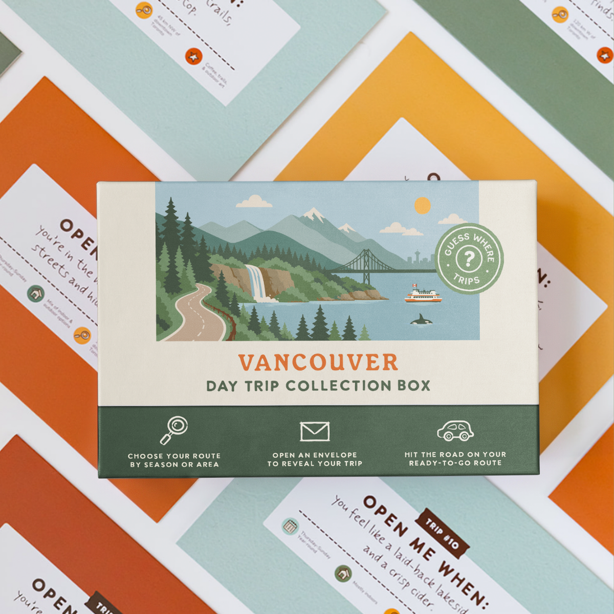 Vancouver Day Trip Box resting on a spread of colourful sealed trip envelopes.