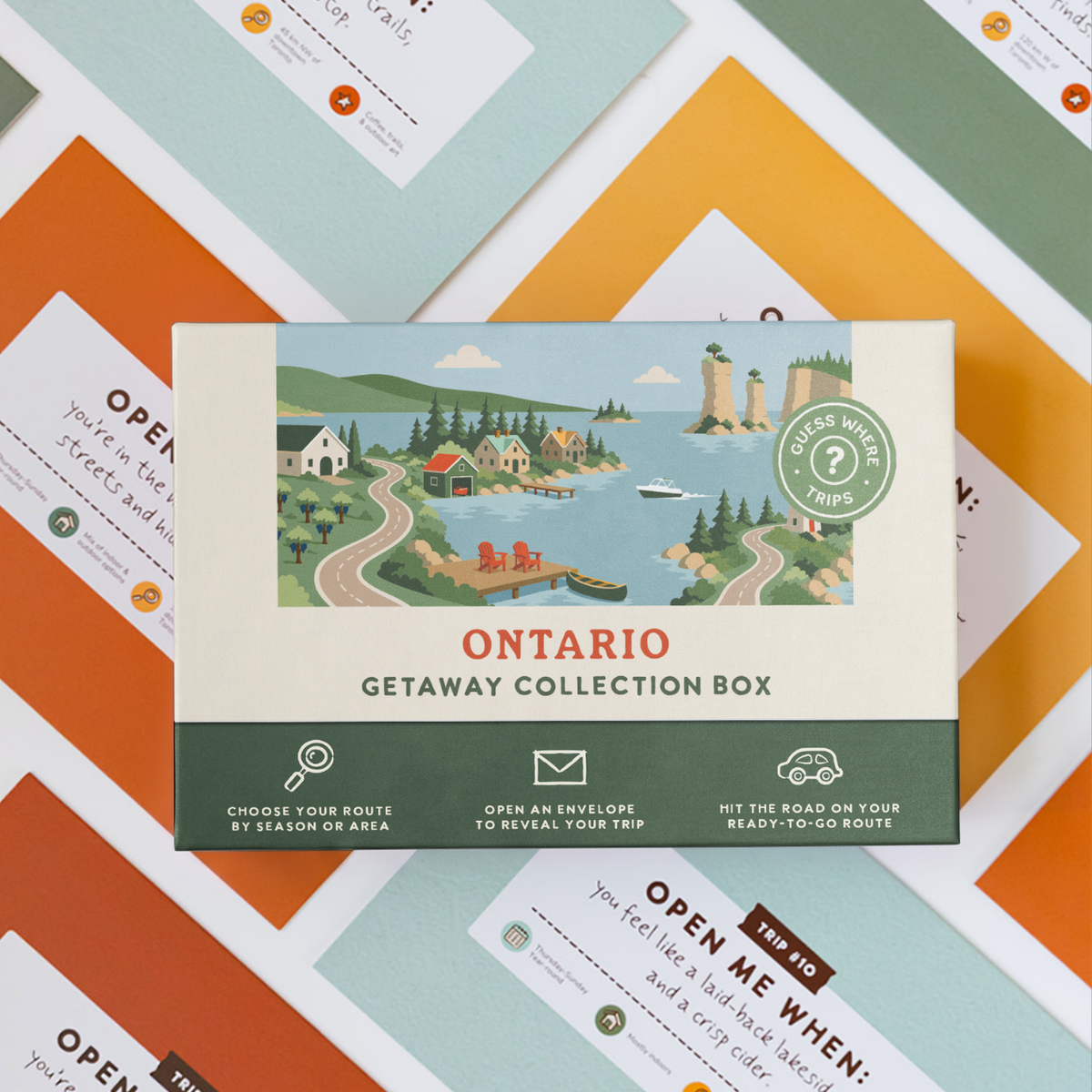Ontario Getaway Box resting on a spread of colourful sealed trip envelopes.