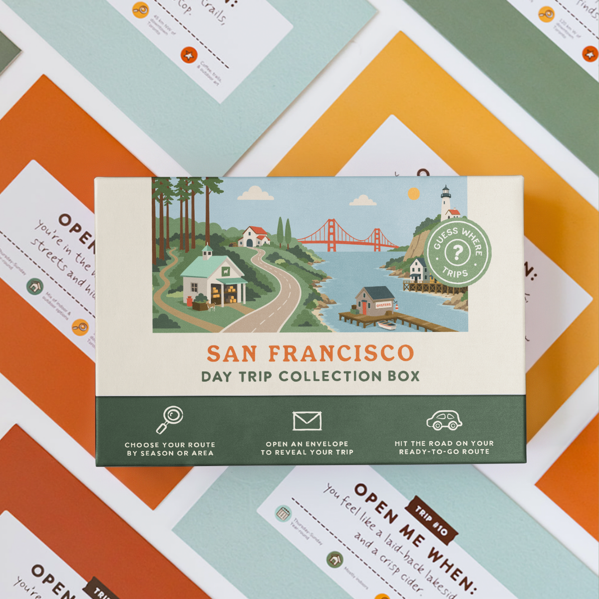Bay Area Day Trip Box resting on a spread of colourful sealed trip envelopes.