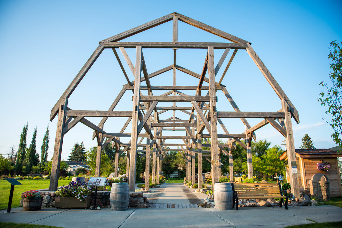 A wooden timber-frame pavilion in a park.