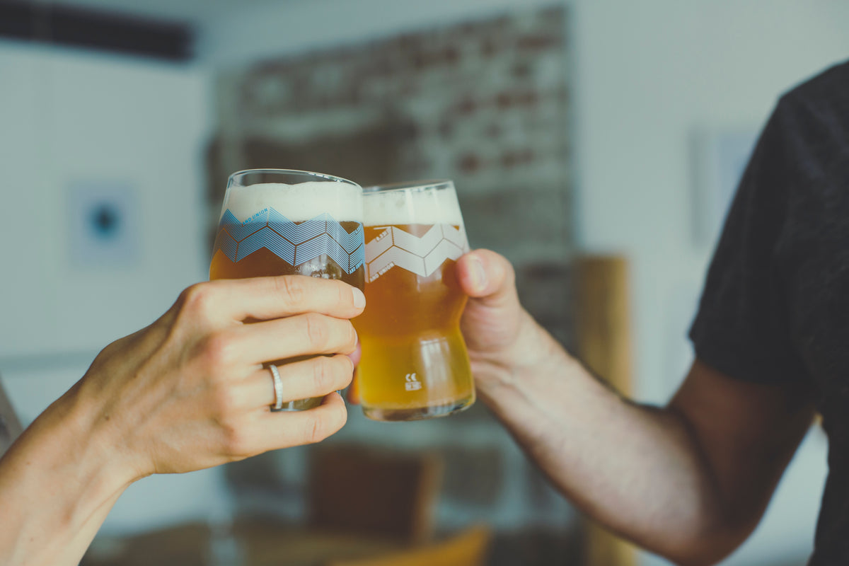 Two people clinking glasses of beer.