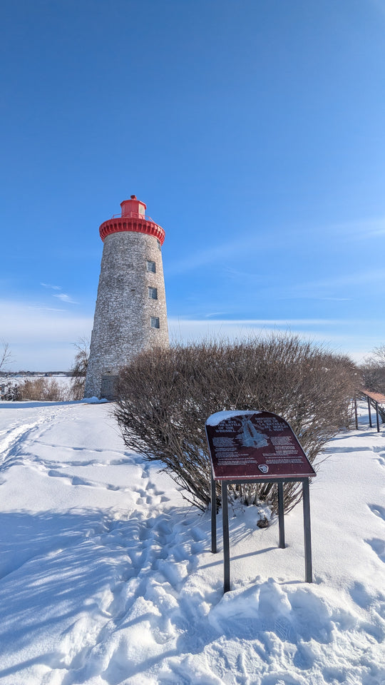 Lighthouse in the snow with a clear blue sky