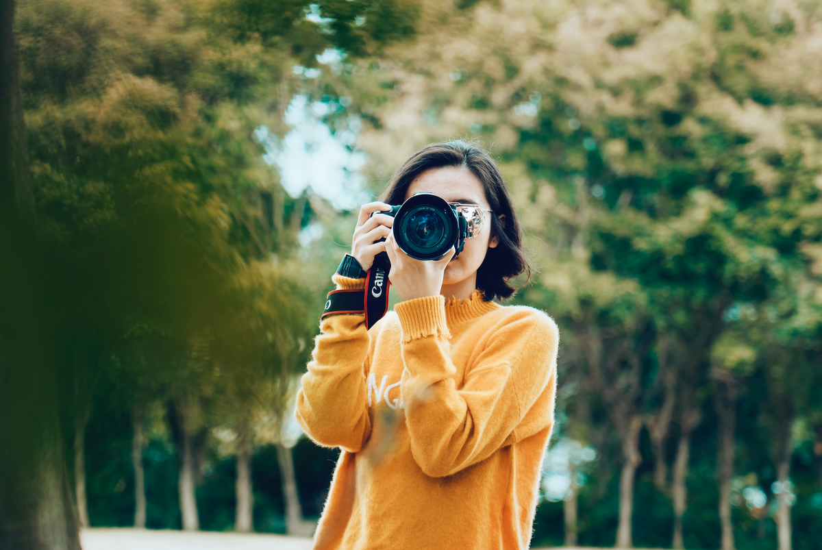 A woman taking a photo with a camera.