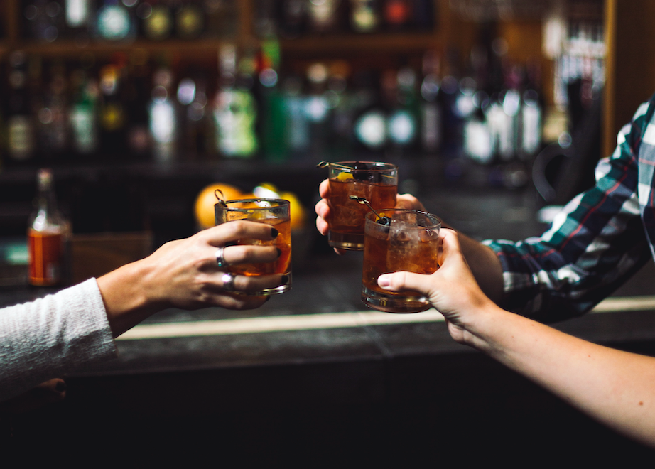 Three people holding their drinks together.