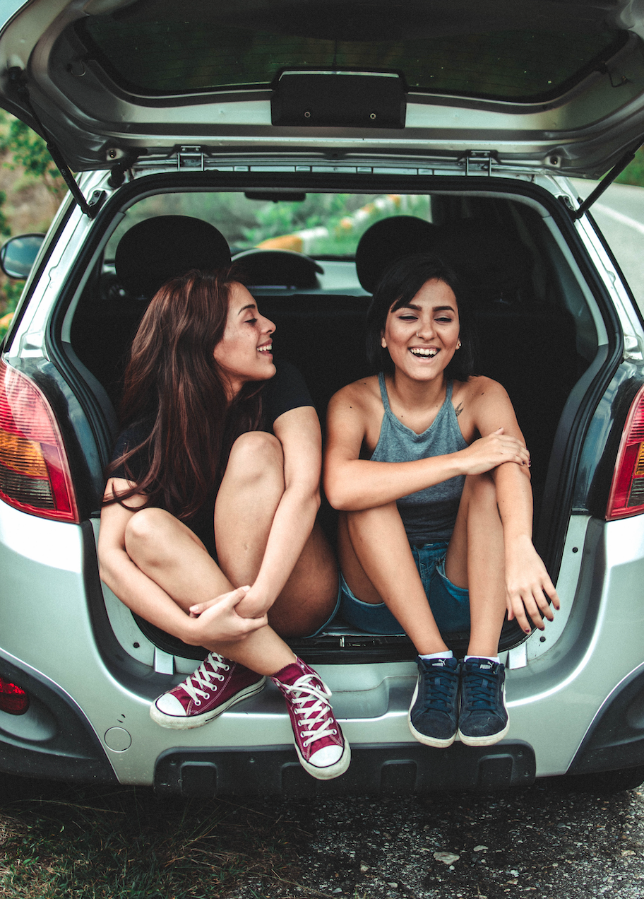 Two girls sitting in back of crossover SUV.