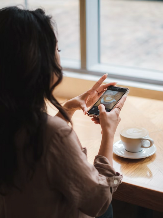 Woman taking photo of coffee.