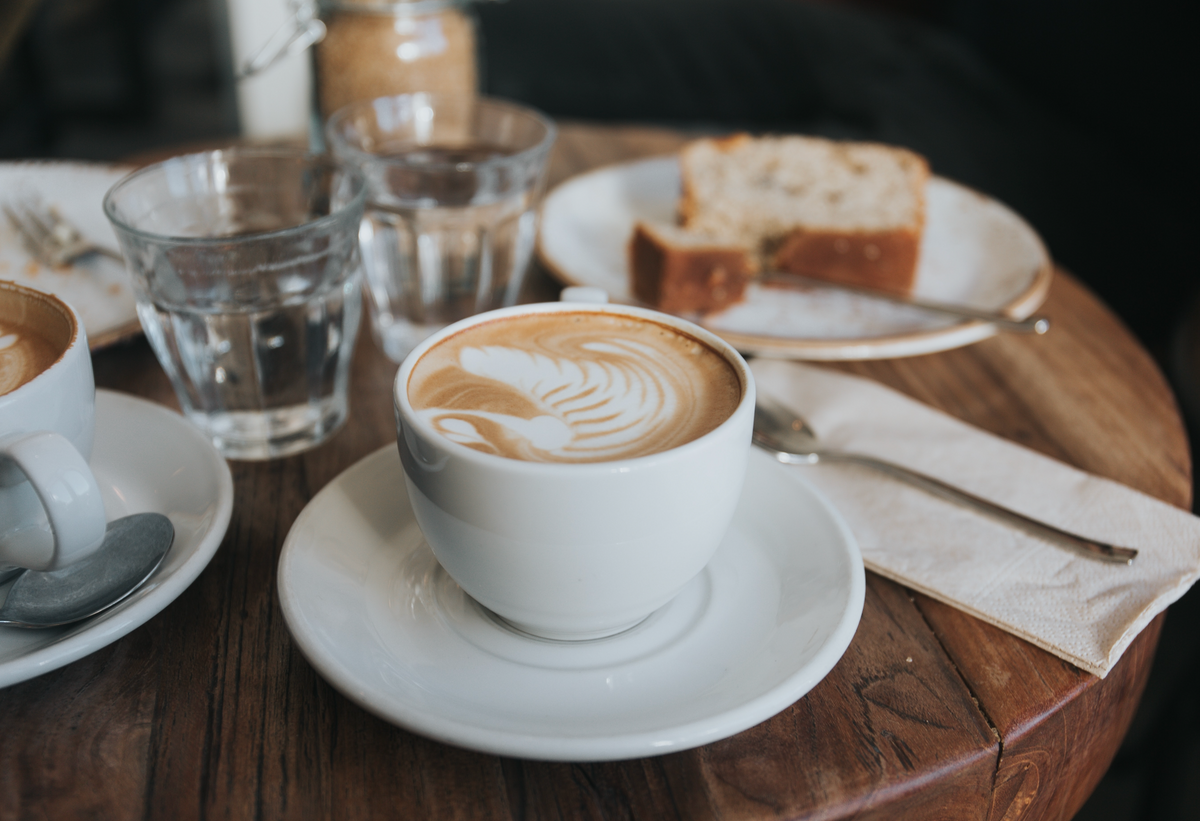 A latte and pastry on a café table.