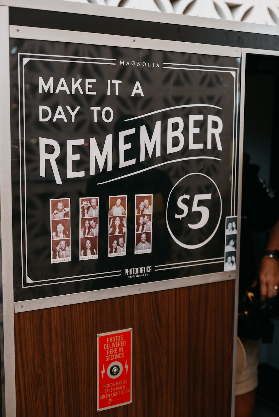 A vintage photo booth sign reading "Make it a day to remember."