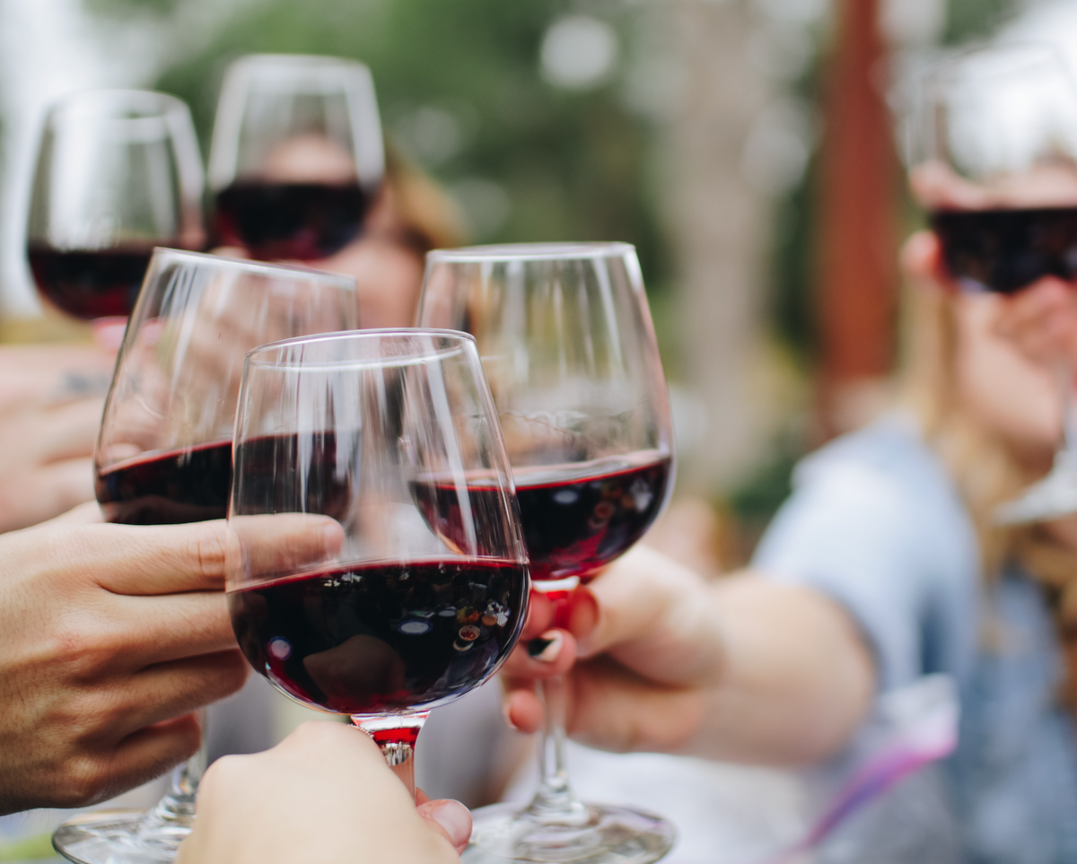 Friends toasting with glasses of red wine.