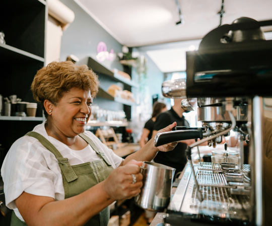 Barista frothing milk in a cafe.