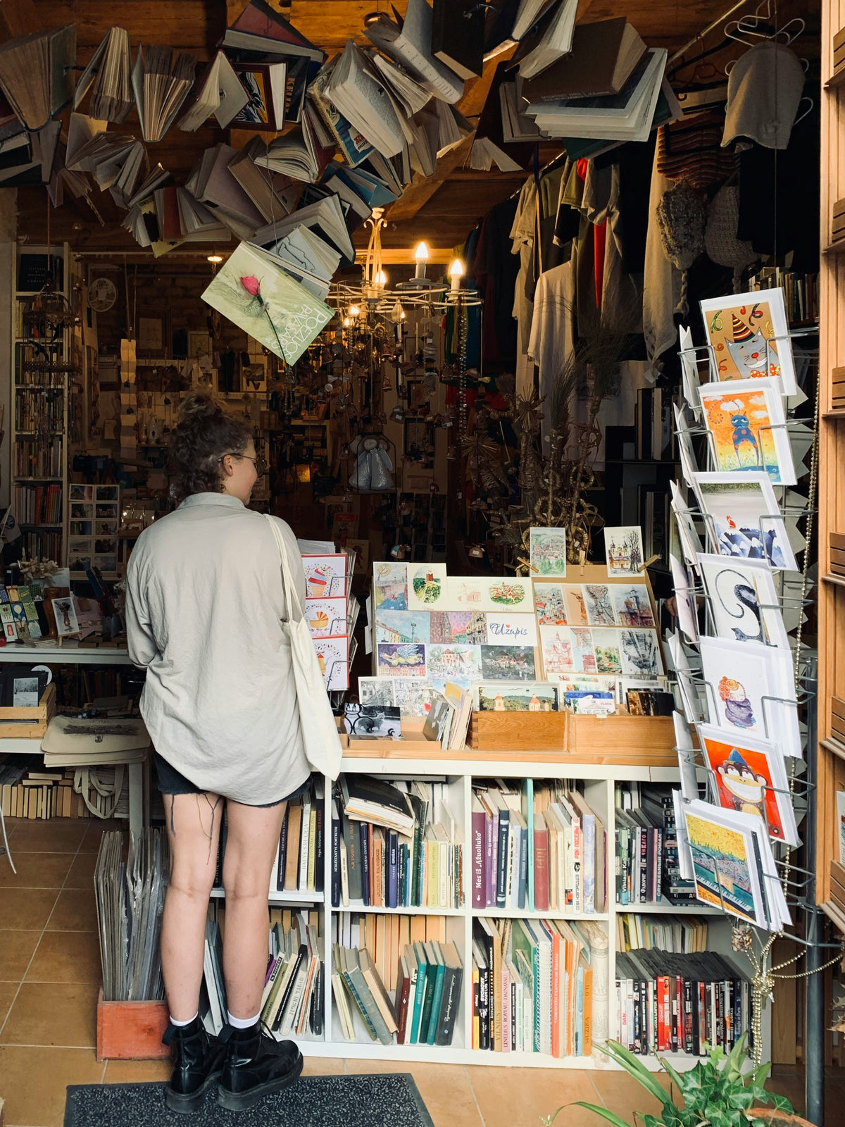 A woman browsing a crowded used bookstore.