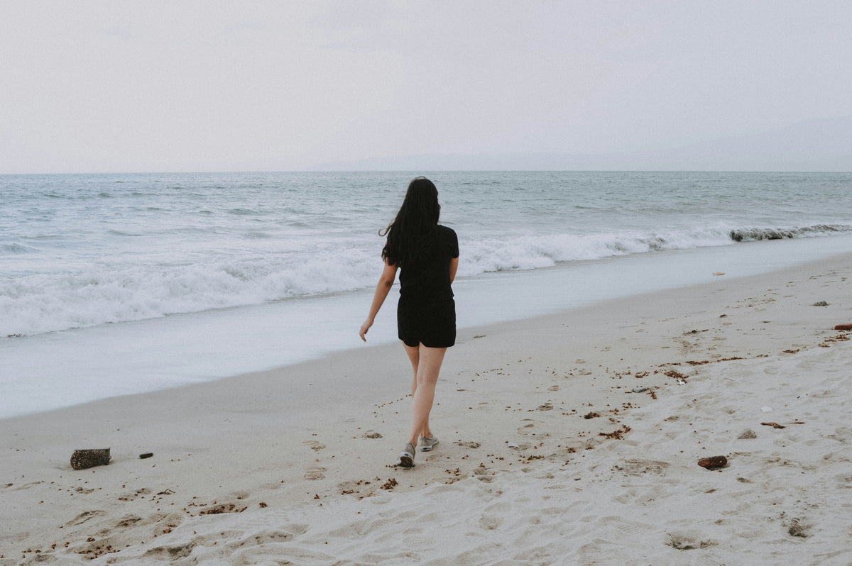 A woman walking along the beach.