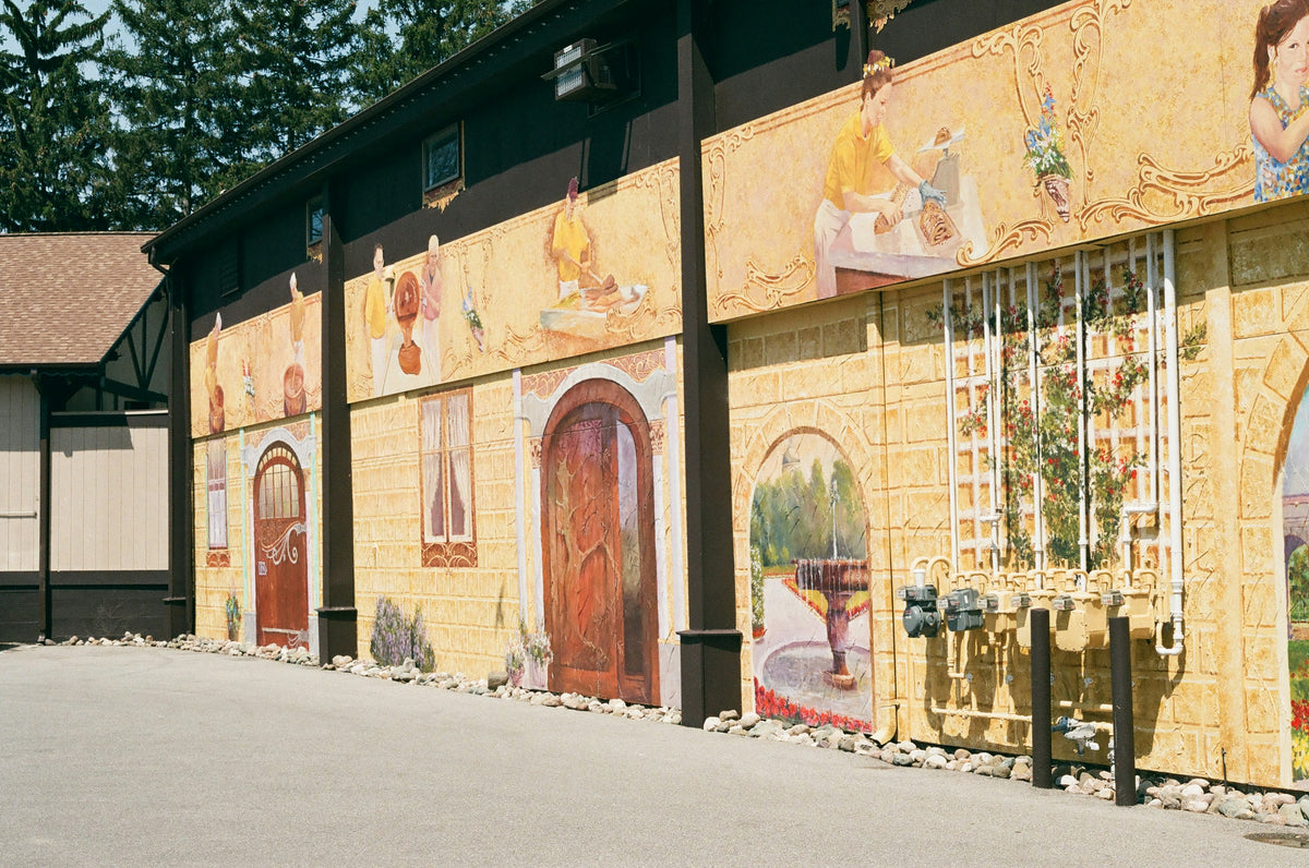 A historic yellow building with red barn-style doors.