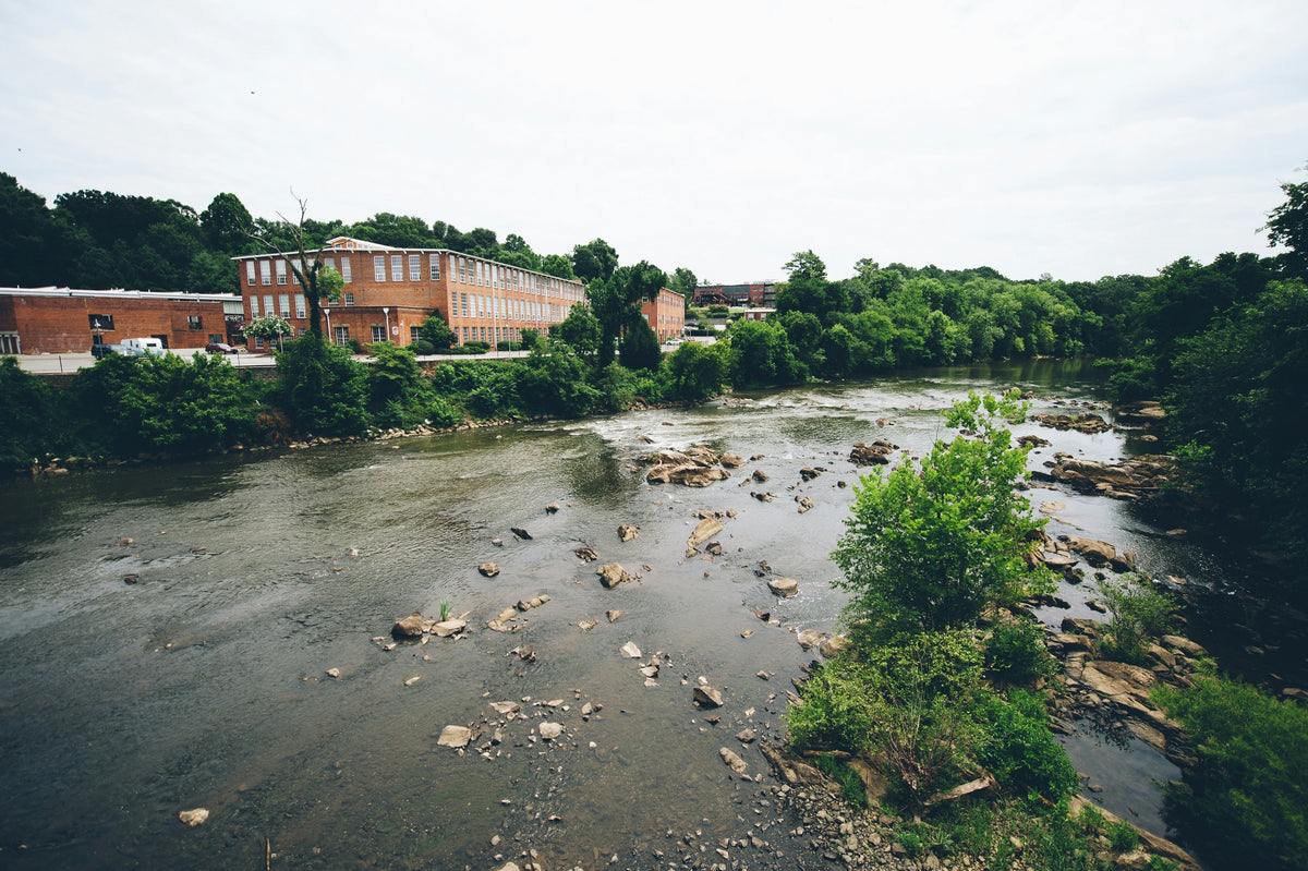 A wide, rocky river running past a small town.