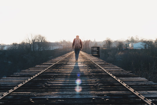 Man walking along railway.