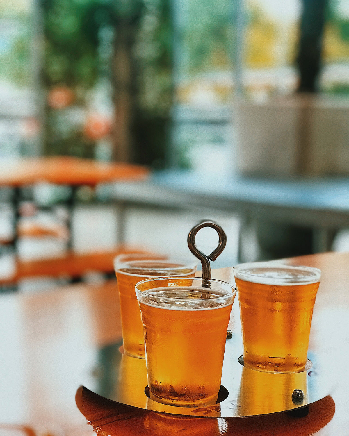 A flight of craft beers on a patio table.