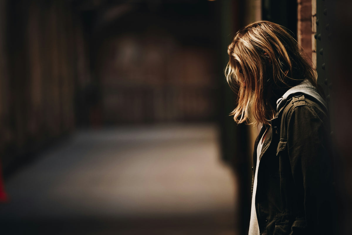 A woman standing in a dimly lit doorway.