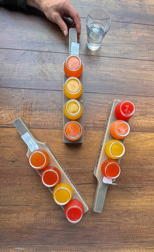 Colourful flights of beer on a wooden table at a brewery.