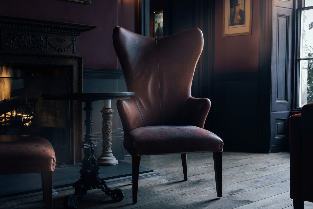A dark, moody room with a vintage armchair.
