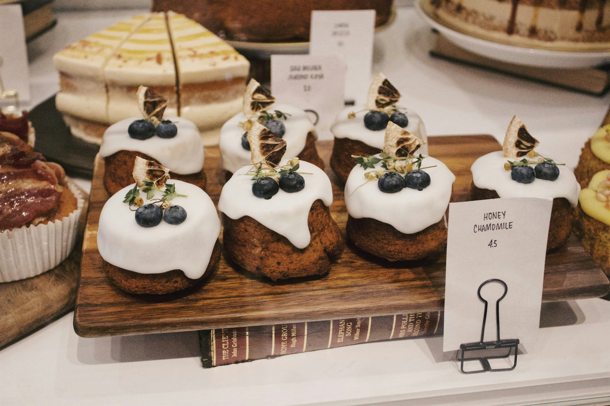 Frosted cupcakes on display at a bakery.