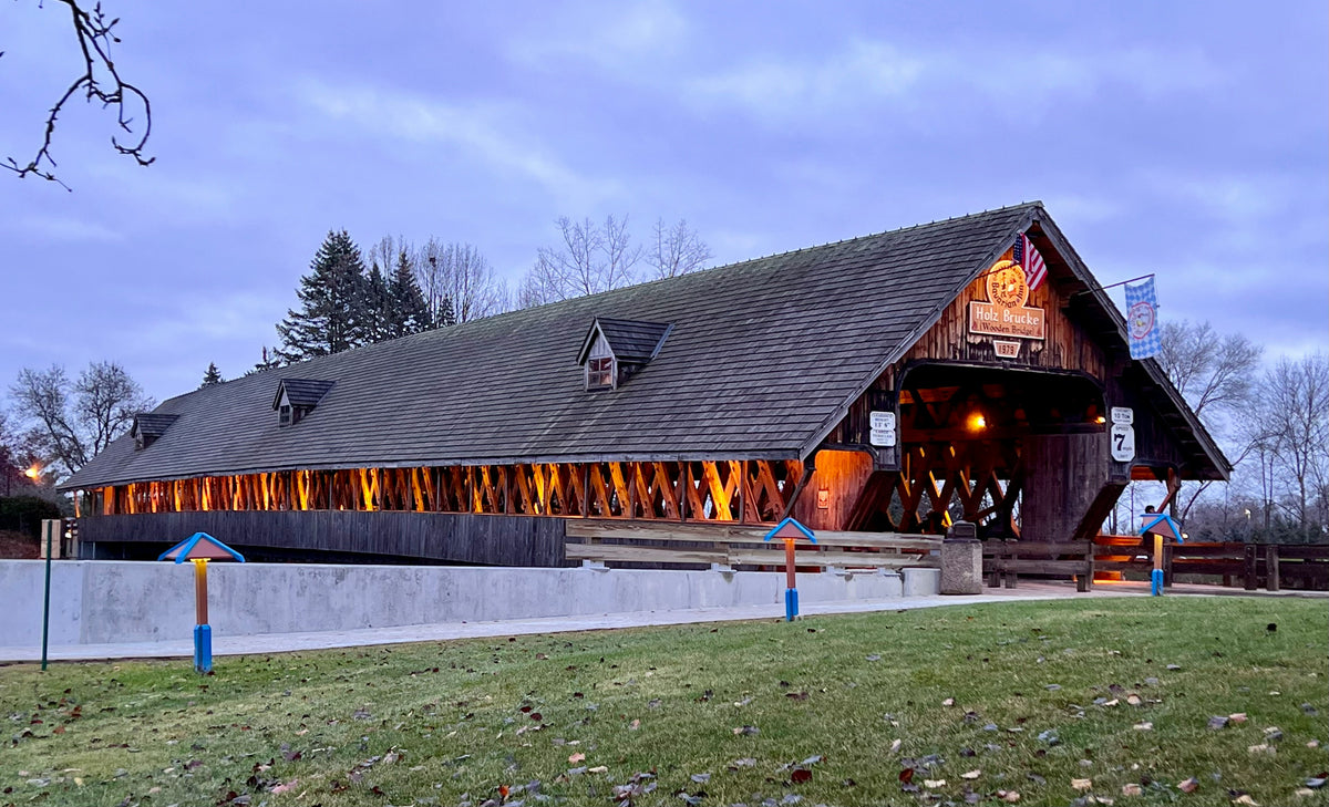 A covered bridge lit up at dusk.