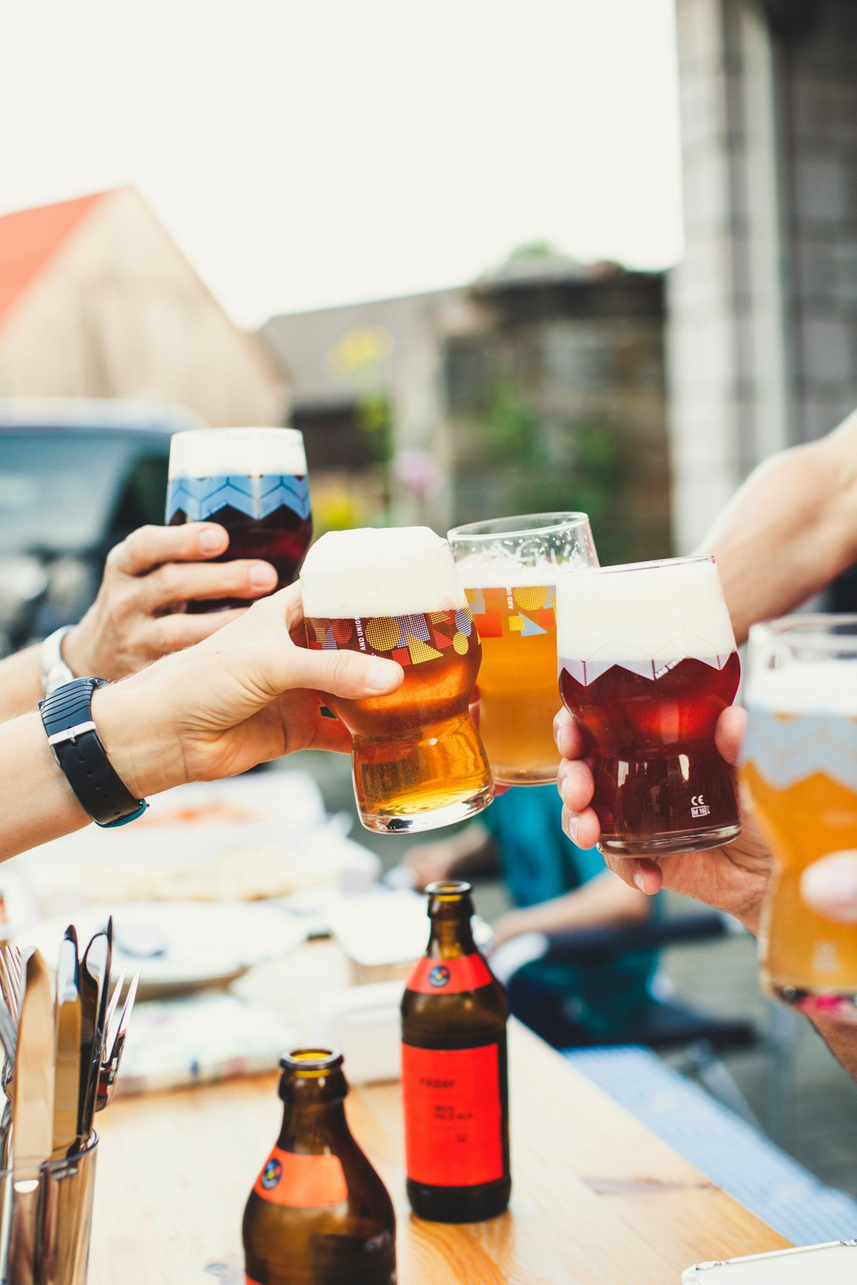 Friends toasting with craft beers at a bar.