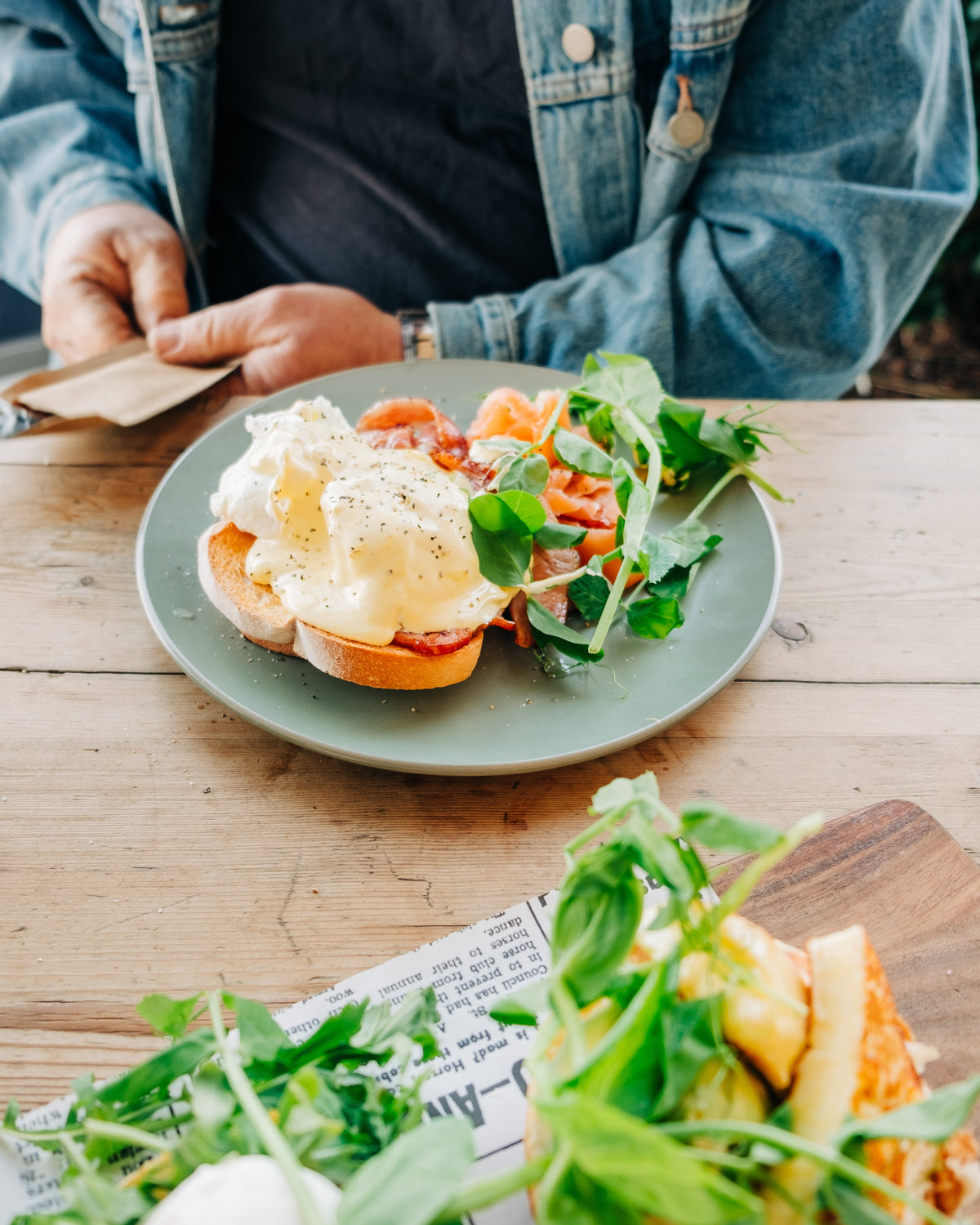 A brunch plate of eggs and greens on a table.