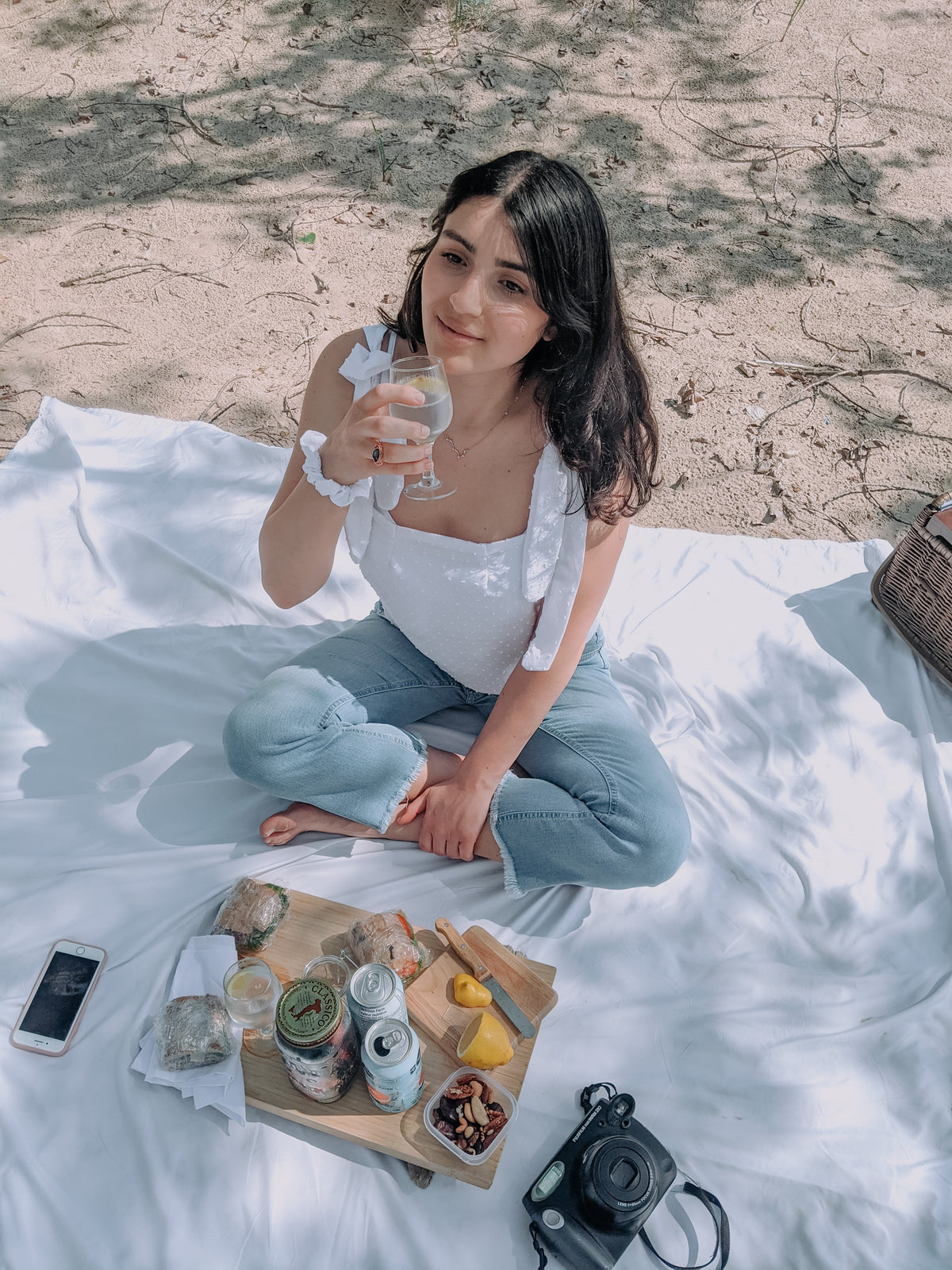 A woman enjoying a picnic on a blanket.