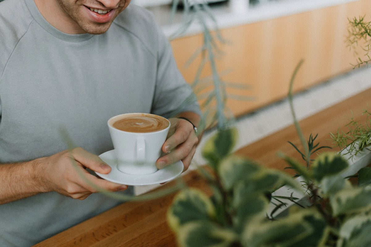 A man sipping coffee at a café.