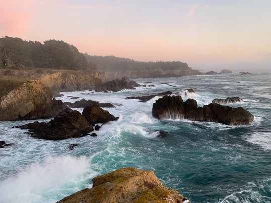 Pacific ocean with waves breaking against rocks.