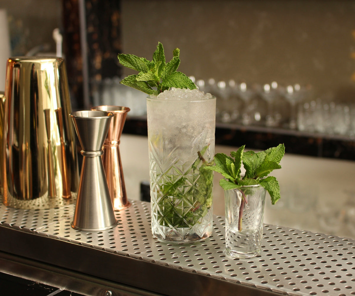 Cocktails being mixed at a bar.