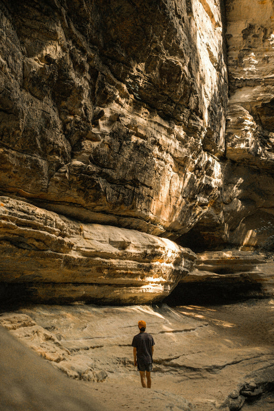 Man standing in front of huge cliff formations