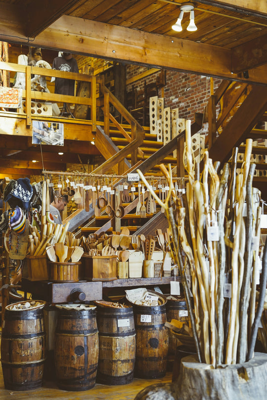 Wooden utensils and barrels displayed in a rustic workshop farm market setting.