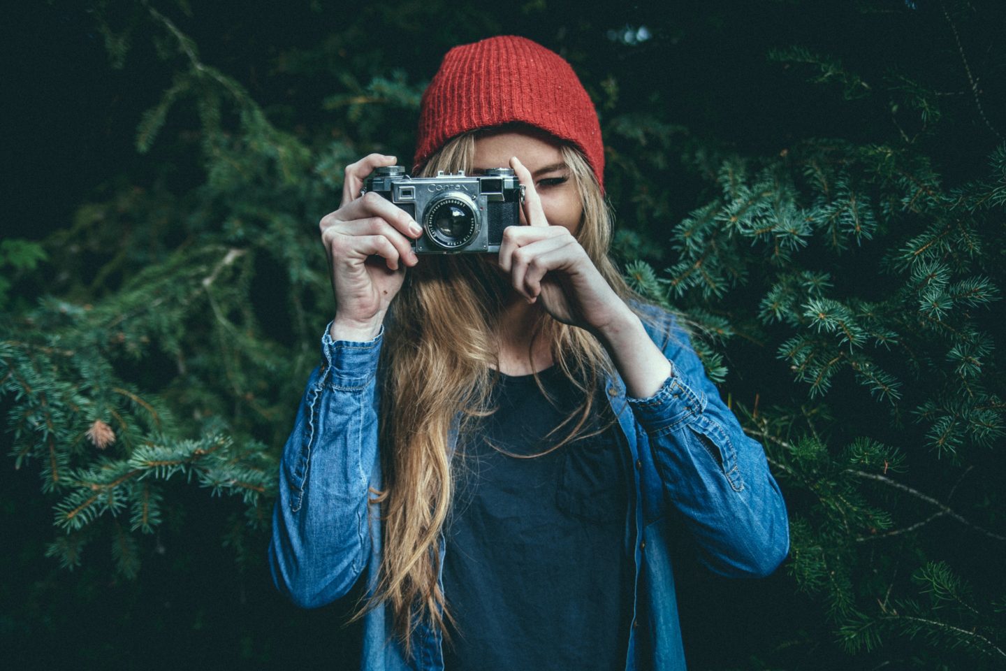 Woman taking a photo with a vintage Canon camera.