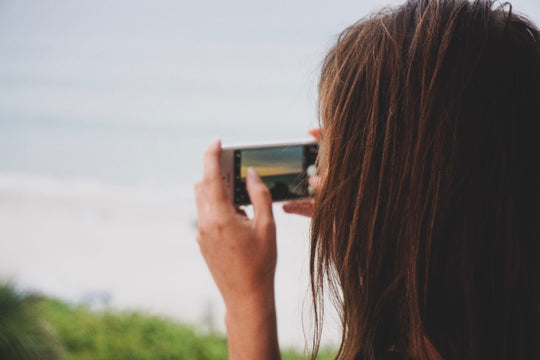 Woman taking a photo of a landscape.