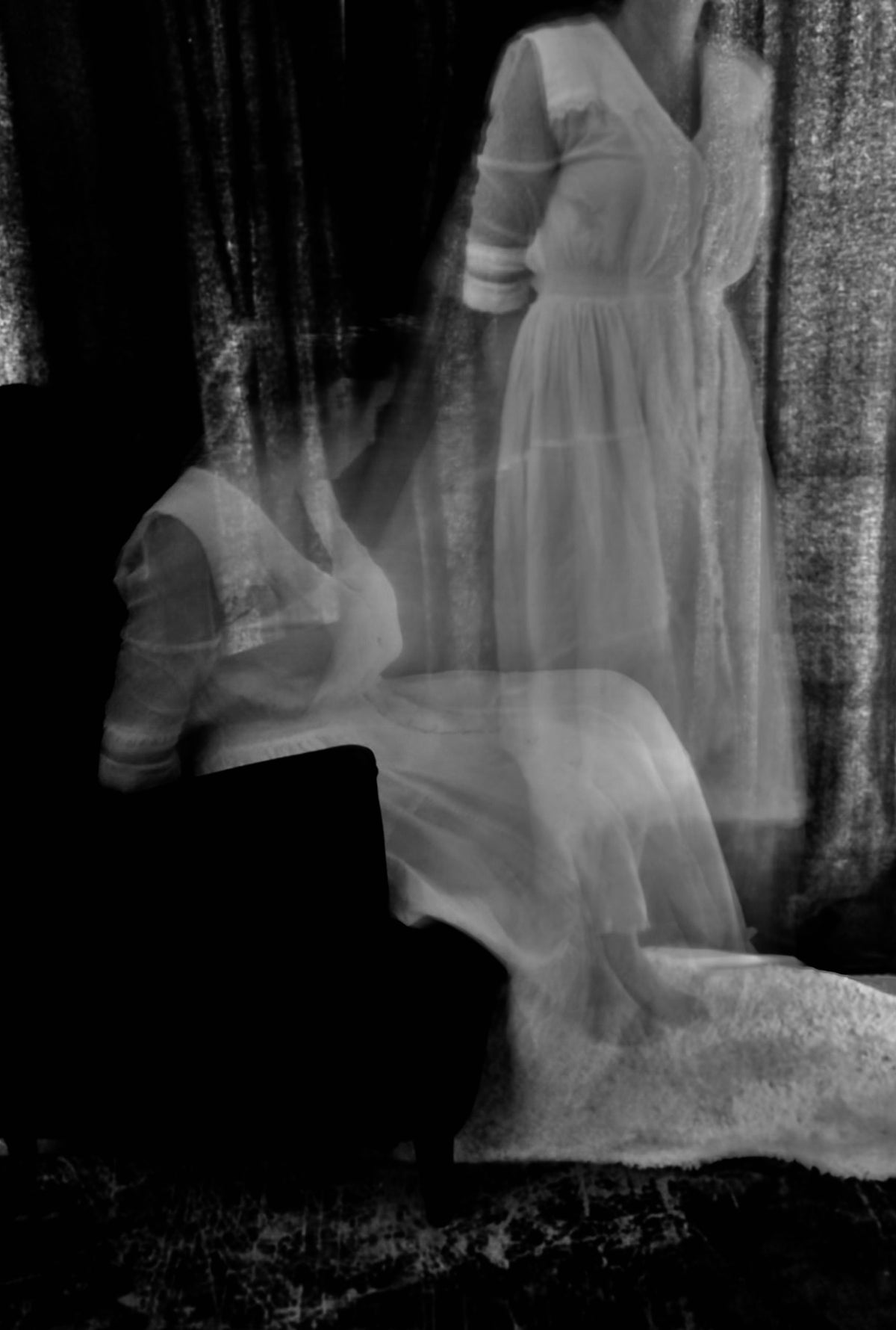 Black and white photo of a ghostly figure in a white dress.