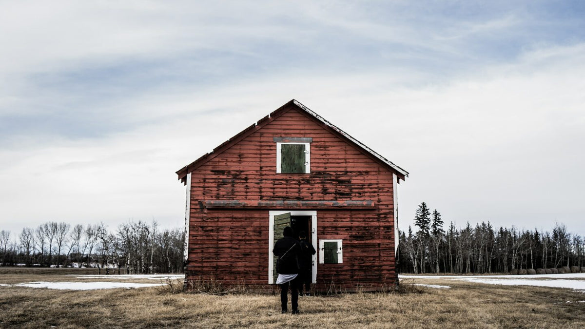 An old red brick schoolhouse on the prairie.