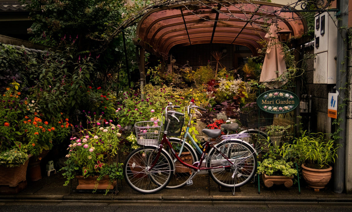 Bikes parked in front of a flower shop.