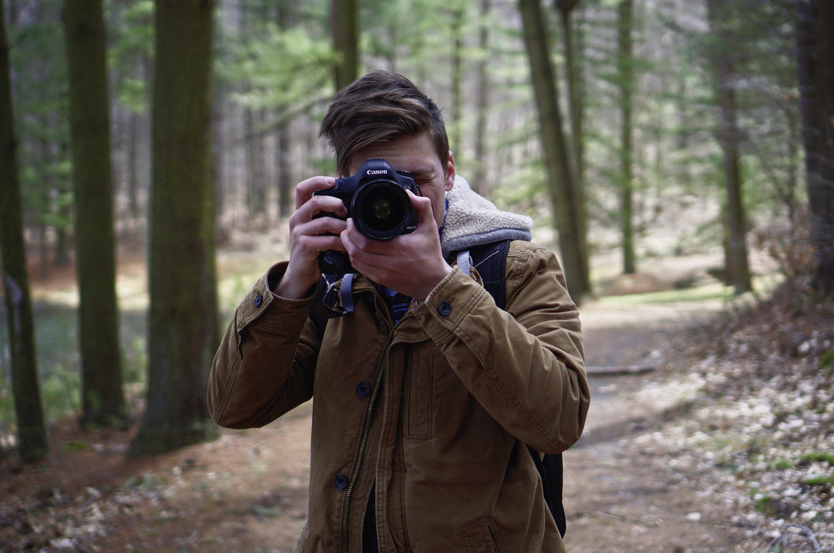 A person with a camera exploring a forested area