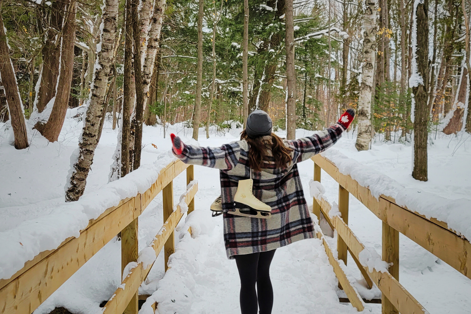 Woman with hat sticking head out of car window on winter road