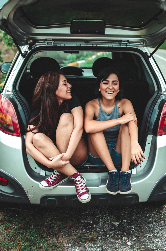 Two girls sitting in back of car on a road trip