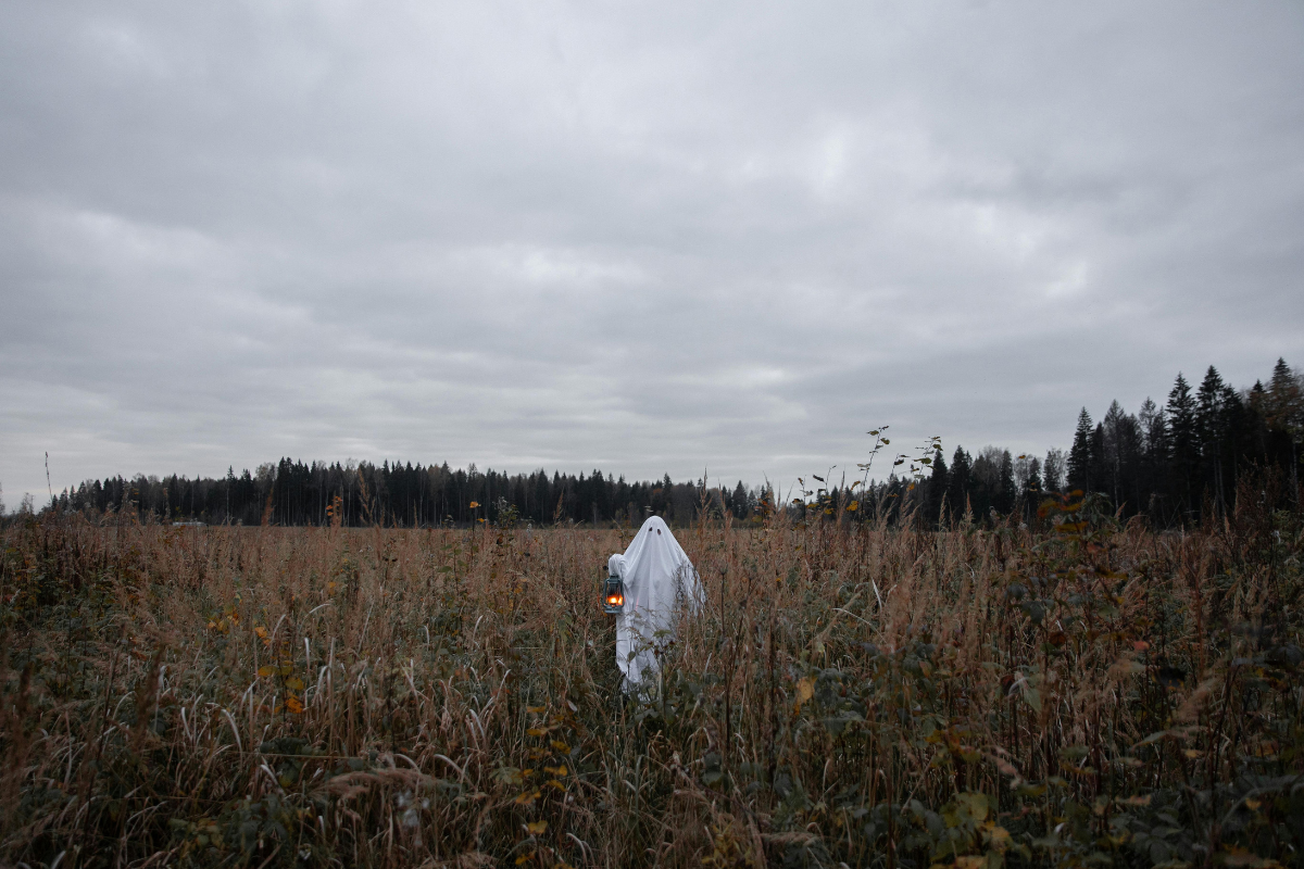 Ghost holding lantern in a field