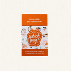 The Surprise Which Way? Road Trip Game box on a light cream textured background. The packaging features a bright orange top and bottom band with white text, and a central white panel decorated with cute illustrations of cars, a backpack, a coffee cup, and a suitcase, all framed by a dashed orange border.