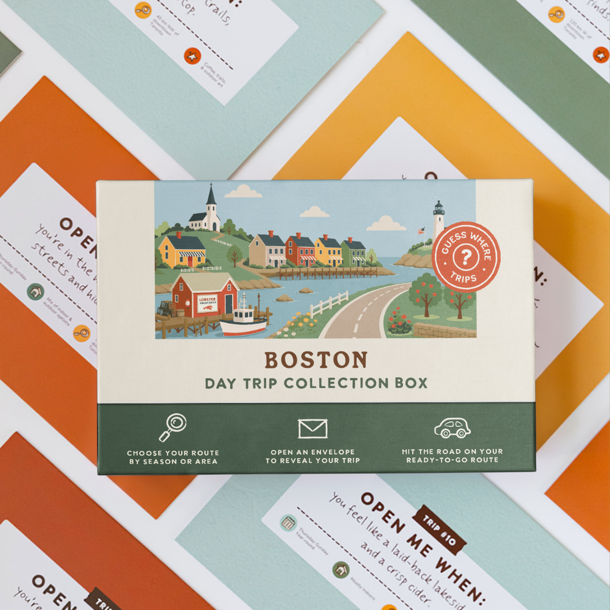 Boston Day Trip Box resting on a spread of colourful sealed trip envelopes.