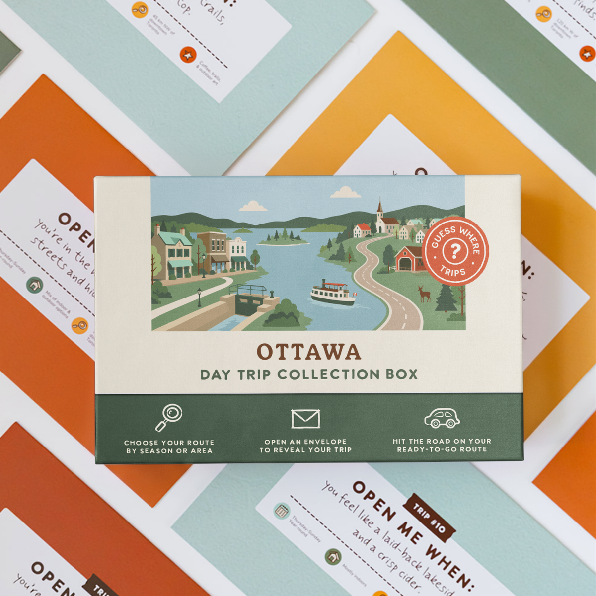 Ottawa Day Trip Box resting on a spread of colourful sealed trip envelopes.