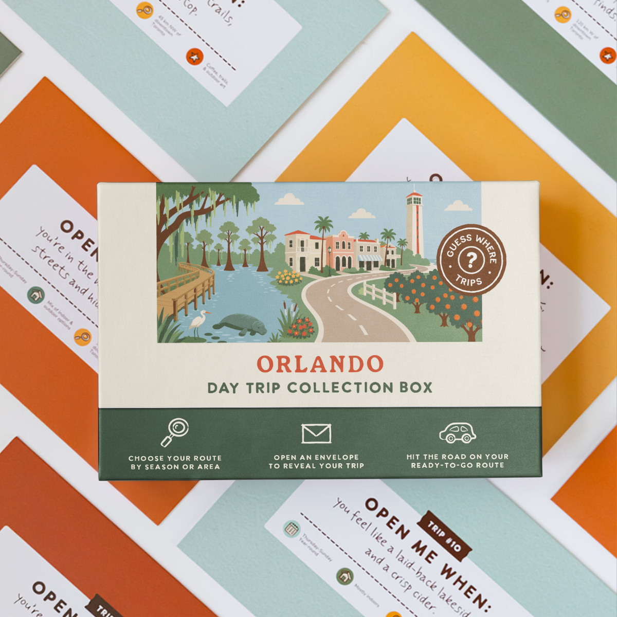 Orlando Day Trip Box resting on a spread of colourful sealed trip envelopes.