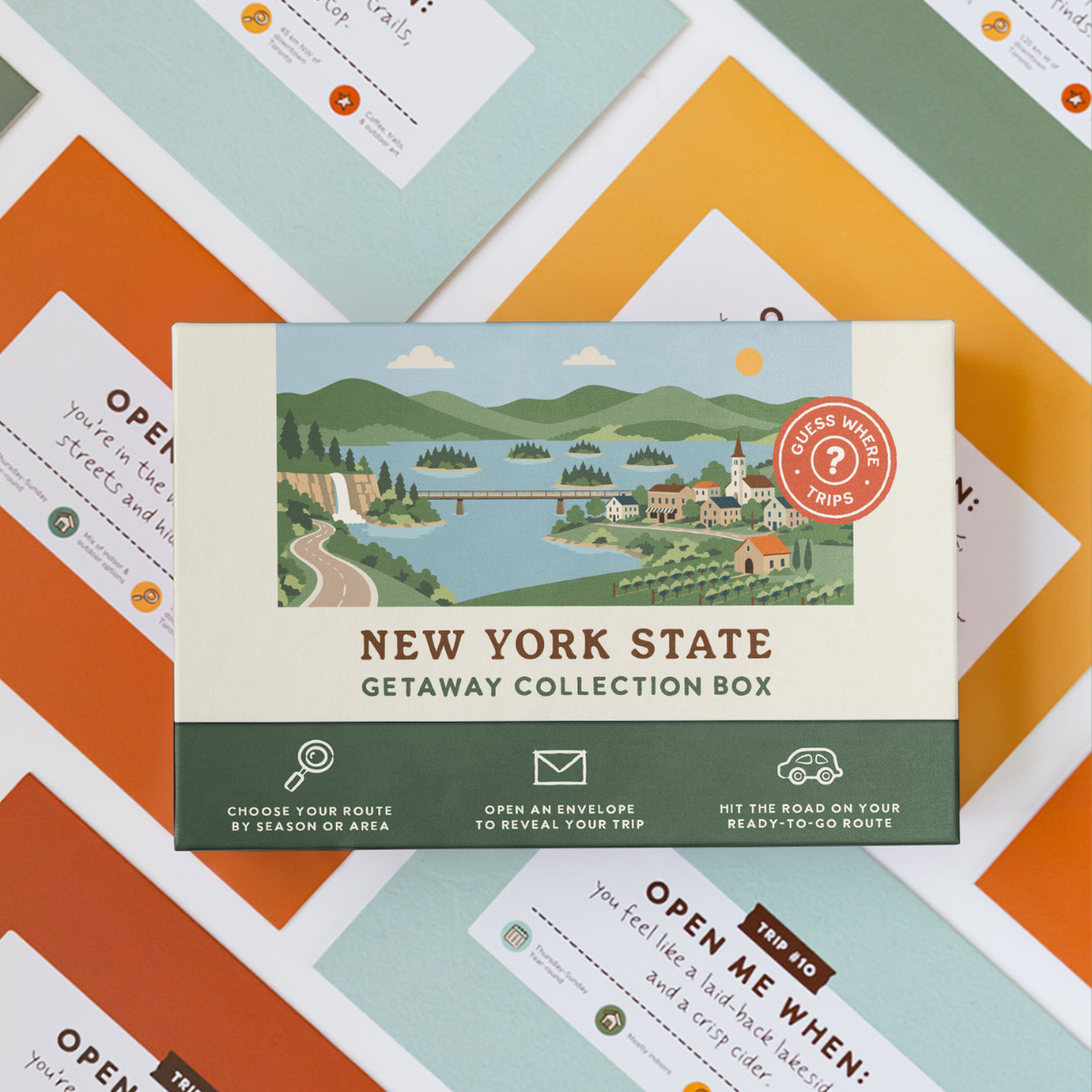 New York State Getaway Box resting on a spread of colourful sealed trip envelopes.