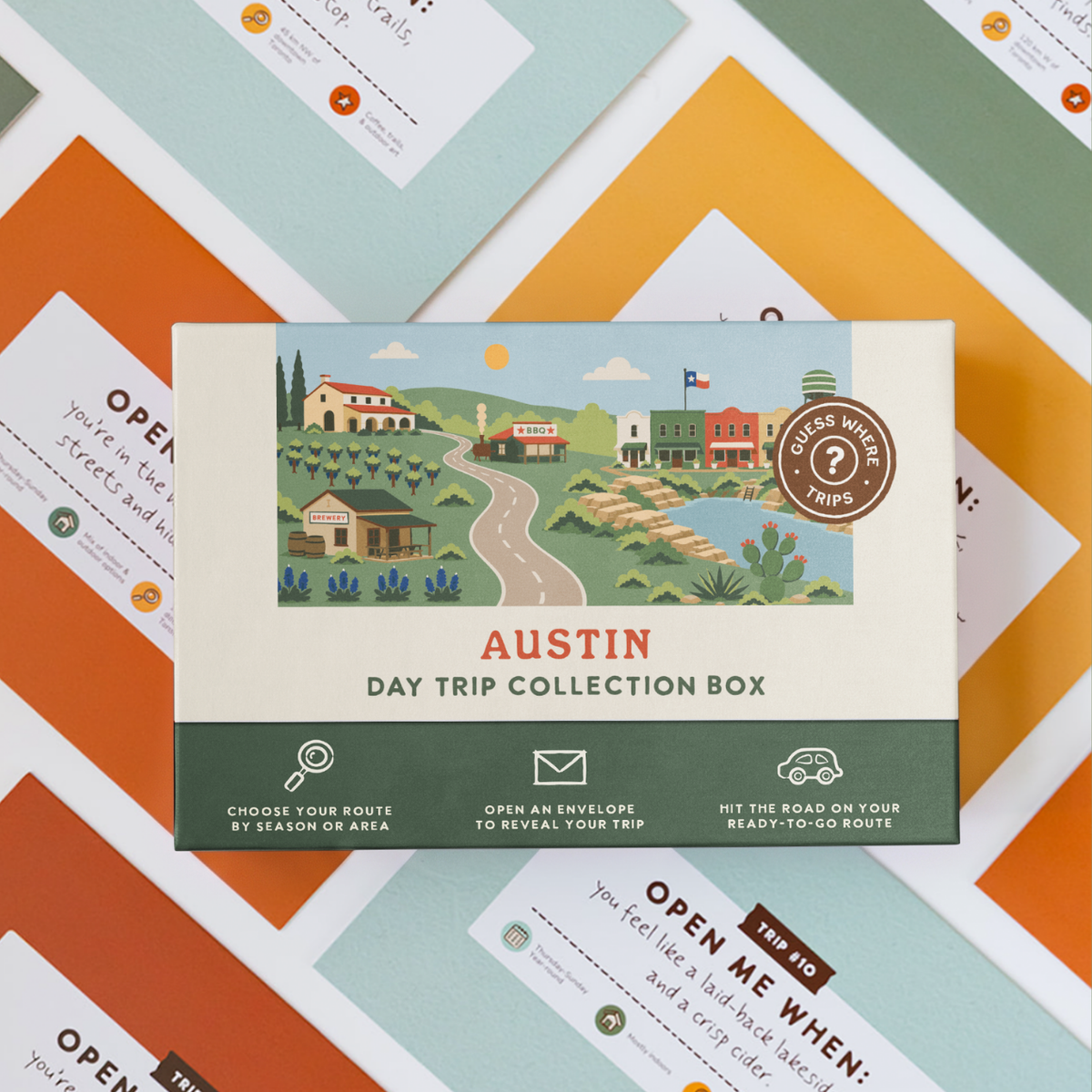 Austin Day Trip Box resting on a spread of colourful sealed trip envelopes.