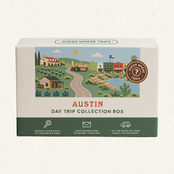 Austin Day Trip Box by Guess Where Trips, illustrated with Texas Hill Country, a winding road, small-town storefronts, a Texas flag and bluebonnets.